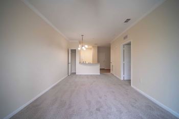 A long, empty hallway with a carpeted floor and white walls.